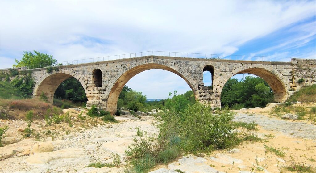 Le Pont Julien de Bonnieux, un pont romain datant de l'antiquité, traverse paisiblement la rivière Calavon dans le Luberon en Provence.