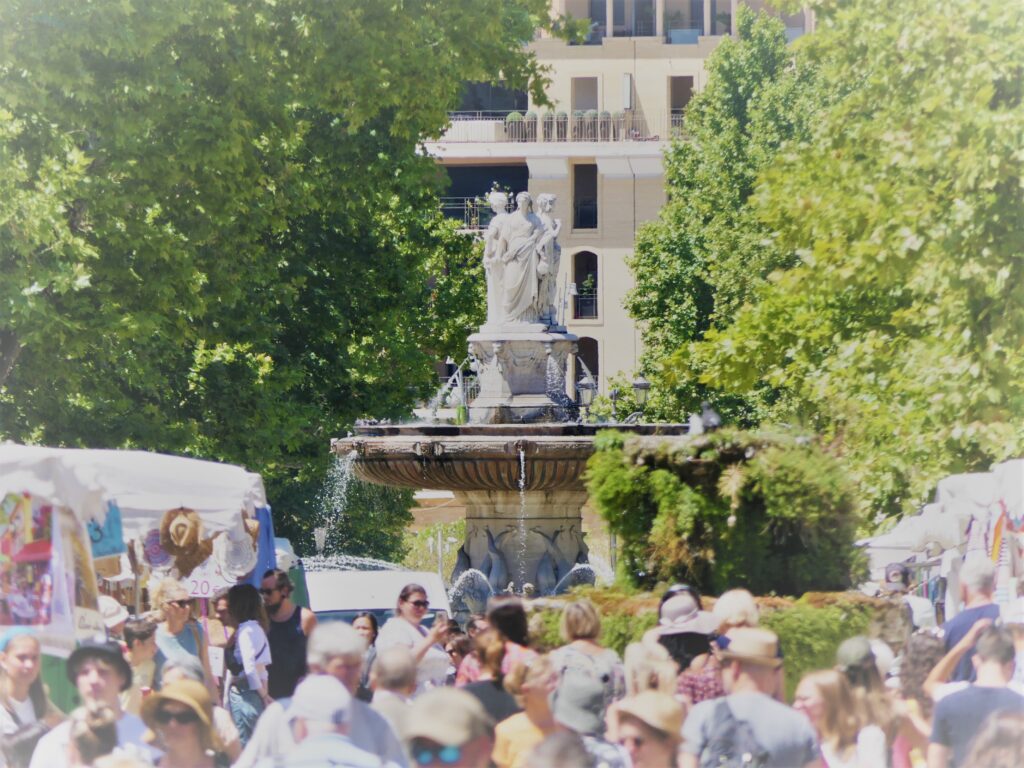 Vue impressionnante de la Fontaine de la Rotonde depuis le Cours Mirabeau à Aix-en-Provence, une représentation majestueuse d'un des points d'intérêt majeurs de la ville.