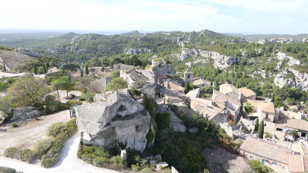Panorama des Baux-de-Provence avec ses maisons historiques et sa nature verdoyante.