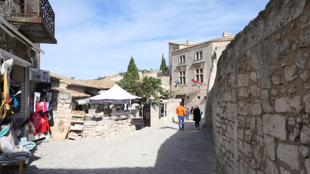 Ruelle aux Baux-de-Provence avec boutiques et bâtiment historique.